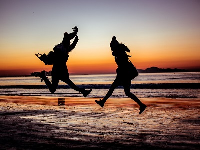 zwei menschen springen am strand