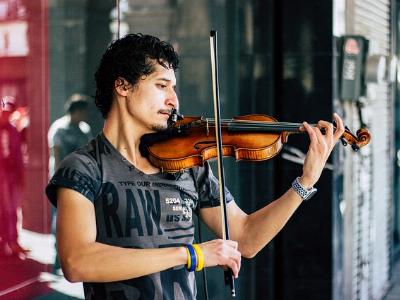 junger Mann spielt auf der Straße Geige