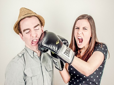 Frau schlägt Mann mit Boxhandschuh