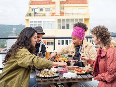 Vier junge Erwachsene sitzen gemeinsam am Tisch und essen. (c) Foto: Pexels Vier junge Erwachsene sitzen gemeinsam am Tisch und essen. (c) Foto: Pexels