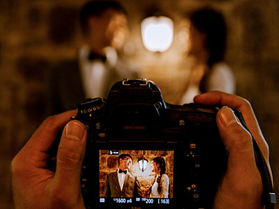 Ein Mann fotografiert ein glückliches Paar. (c) Foto: Pexels