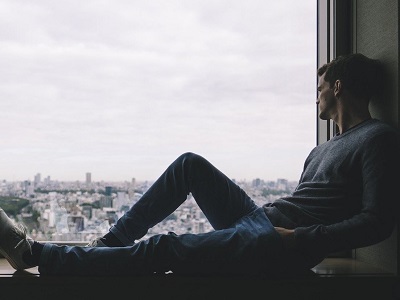 Nachdenklicher Mann sitzt am Fenster