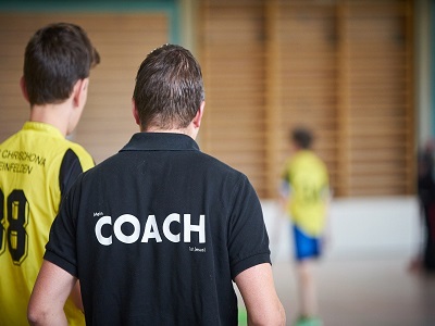 Ein Trainer mit einem Sportler in der Turnhalle