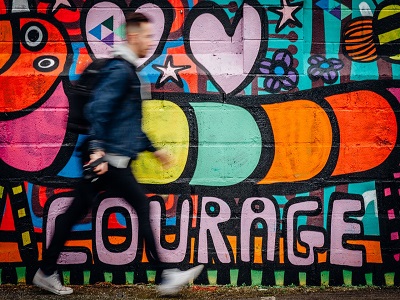 Mann geht an Graffitispruch ´Courage´ vorbei