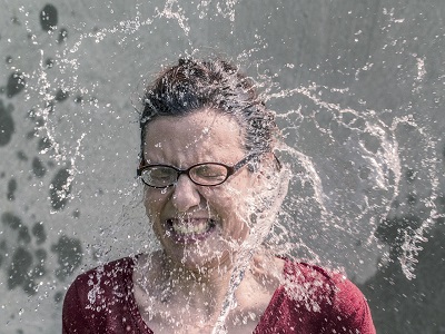 Eine Frau erfrischt sich mit Wasser