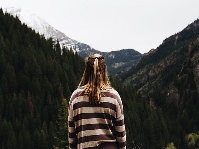 Frau schaut in eine Berglandschaft