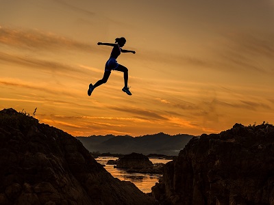 Frau springt über Felsen