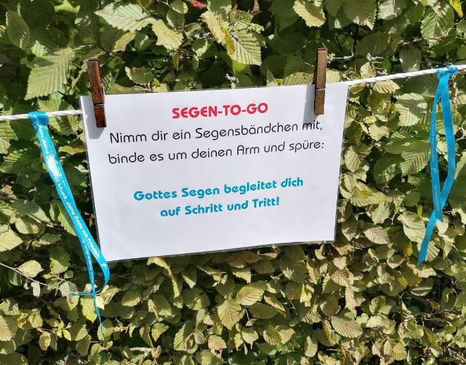 Segensbändchen hängen neben einem Schild