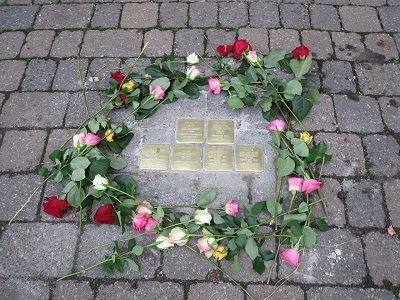 Stolpersteine mit Blumen umrandet