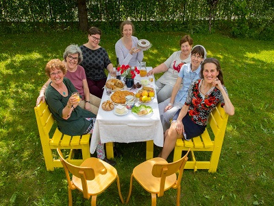 Frauen sitzen an einem Tisch im Garten